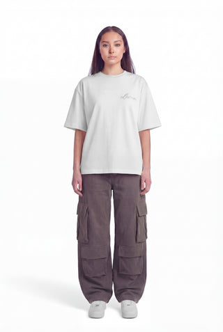 Person wearing a white oversized t-shirt and brown cargo pants on a white background