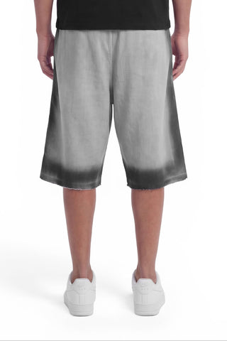 Person wearing gray gradient shorts on a white background